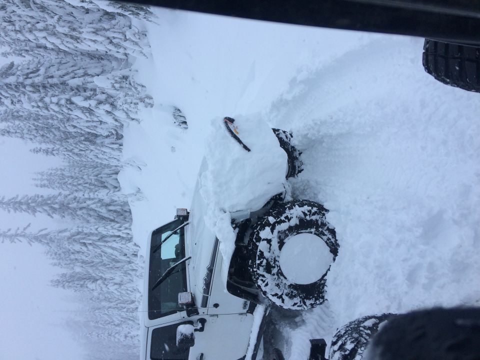 White 1995 Jeep YJ in deep snow, front 3/4 view