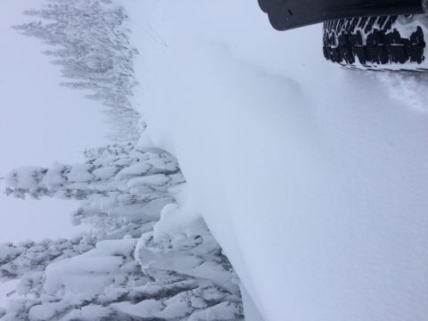 1995 Jeep Wrangler - A vehicle navigates through deep snow, with only a tire and part of the body visible.