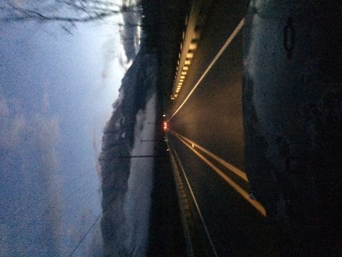 1995 Jeep Wrangler - A view down a highway at dusk, with a single vehicle's taillights visible in the distance.