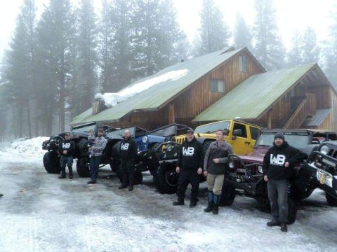 1995 Jeep Wrangler - A group of people stand with their modified Jeeps in a snowy environment outside a wooden lodge.