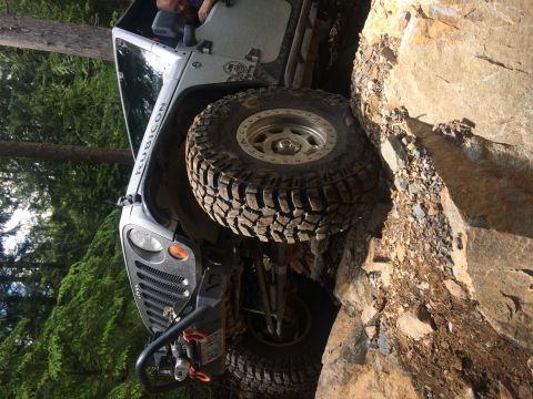1995 Jeep Wrangler - This Jeep Wrangler Rubicon is navigating a challenging rocky terrain on a trail.