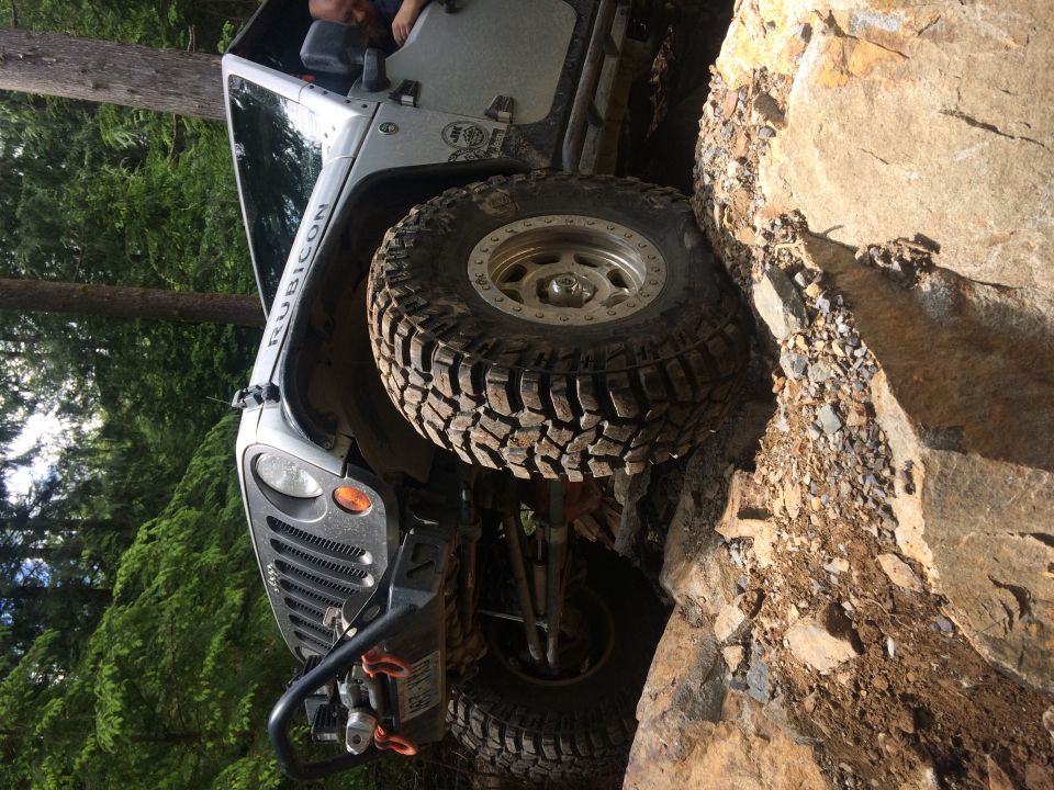 White Jeep Wrangler Rubicon climbing rocks, 2003 model