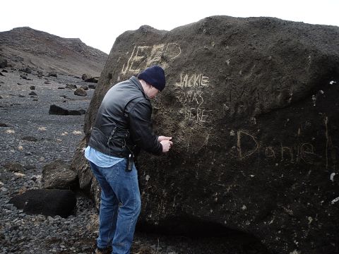 1996 Ford Bronco - Graffiti is scrawled on a large rock, including the words 'JEEP' and 'Jackie was here'.