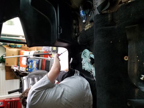 1971 Ford Mustang - Interior view of a vehicle with a person working, boxes and supplies visible.