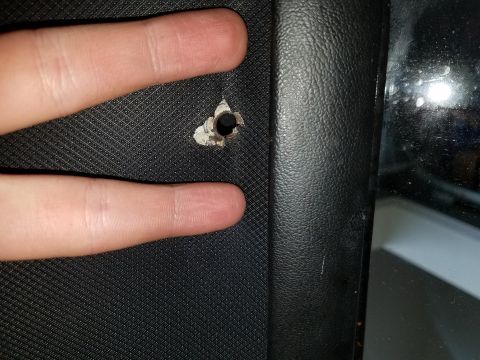 1971 Ford Mustang - A close-up shot shows a damaged section of black car interior trim, with a hole punched through it.