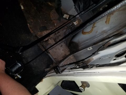 1971 Ford Mustang - Installing a seatbelt in a car's interior, focusing on the floor and mounting hardware.