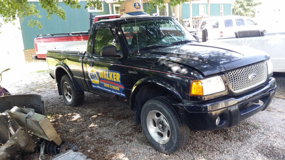 Black Ford Ranger pickup with NAPA Walker Auto & Truck door graphics, front 3/4 view on gravel lot