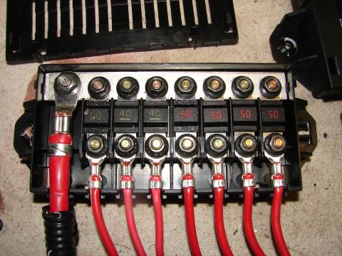 1973 Ford Ranchero - Close-up of a car's fuse box showing several fuses and connected red electrical wires.