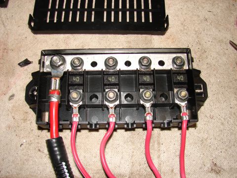 1973 Ford Ranchero - A close-up view of a vehicle's electrical fuse box, showing several 40-amp fuses and connected red wires.
