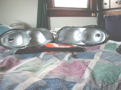 1997 Ford Taurus - These car parts are laid out on a bed with a window in the background.