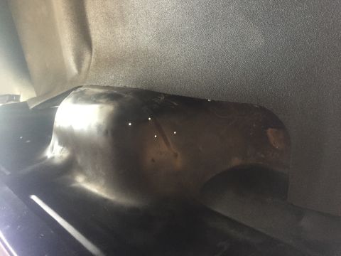 1978 Ford Bronco - Close-up view of the interior of a vehicle's wheel well, revealing the metal structure and some minor wear.