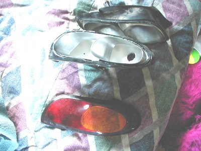 1997 Ford Taurus - Car parts, including headlights and a taillight, are laid out on a patterned cloth.