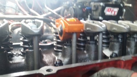 1981 Ford Bronco - Engine valve train components, including an orange roller rocker arm, are visible in this close-up view.