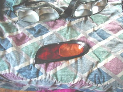 1997 Ford Taurus - Car parts including a taillight and two headlights are displayed on a patterned cloth.