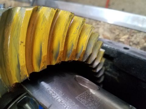 1995 Ford Bronco - Close-up of a yellow ring gear and pinion shaft, indicating wear on the gear teeth.