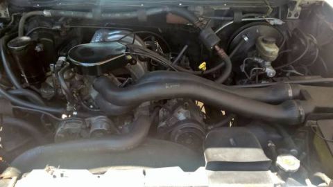1990 Ford Bronco - Close-up view of the engine compartment, showing various mechanical parts and wiring.