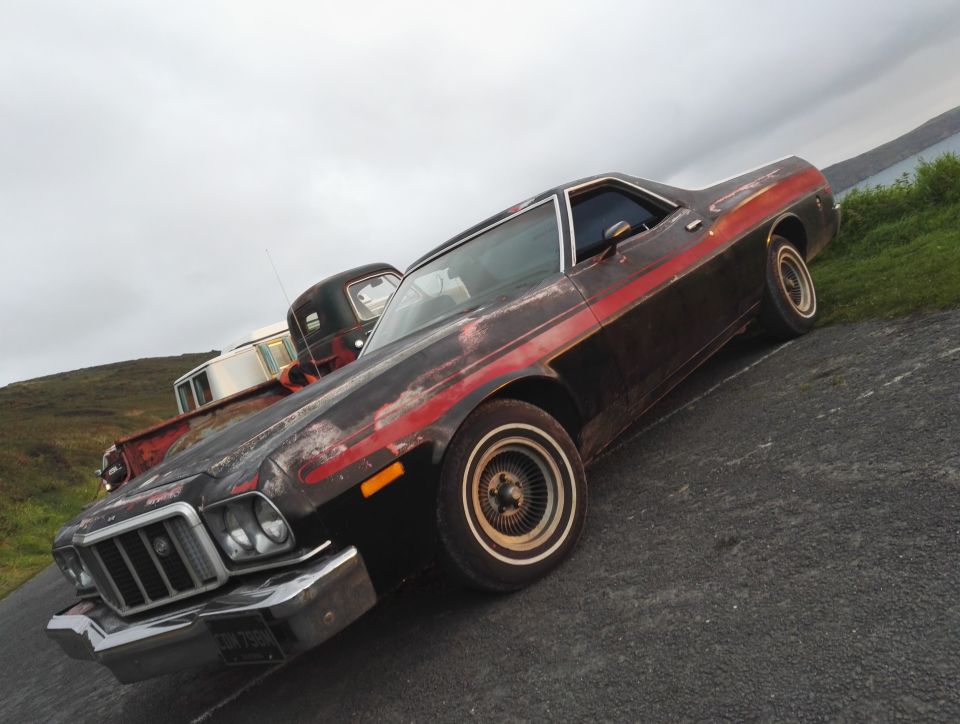 1974 Ford Ranchero with red stripe, front 3/4 view. Worn paint