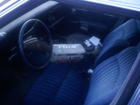 2001 Ford Crown Victoria - Interior view shows blue velour seats and a box of Pilot brand items on the passenger side.