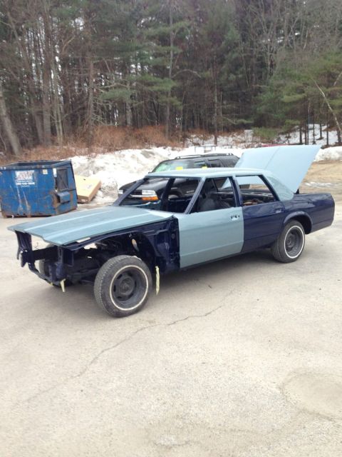 2001 Ford Crown Victoria - Sedan in a state of disrepair, with mismatched body panels and open hood and trunk.