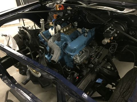 2001 Ford Crown Victoria - The engine bay of a vehicle under construction, showing a blue V8 engine and chassis components.