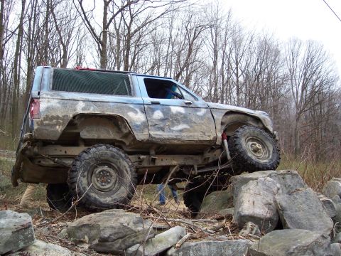 1978 Ford Bronco - Muddy 1978 Ford Bronco navigates a rocky obstacle course during an off-road excursion.