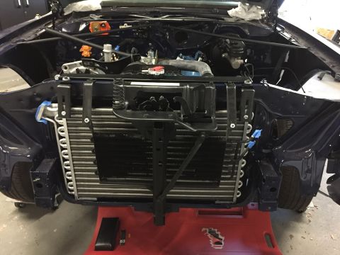 2001 Ford Crown Victoria - The front end of a vehicle is disassembled, revealing the engine and radiator assembly, likely undergoing maintenance or restoration.