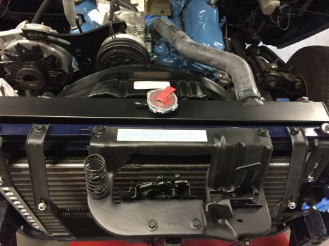 2001 Ford Crown Victoria - Close-up view of a vehicle's engine bay, highlighting the radiator, alternator, and a blue-painted engine block.