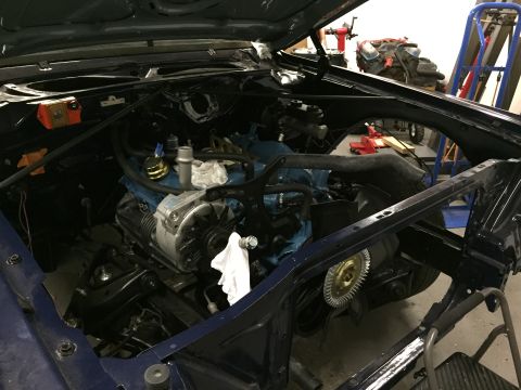 2001 Ford Crown Victoria - The engine bay of a vehicle, showing the engine block, alternator, and various hoses and wires.