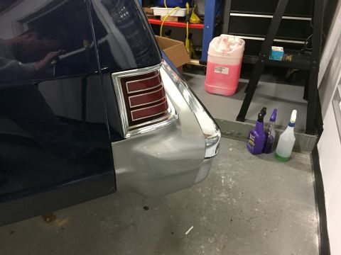 2001 Ford Crown Victoria - A close-up view of a car's rear quarter panel and bumper, showing a distinctive taillight design.