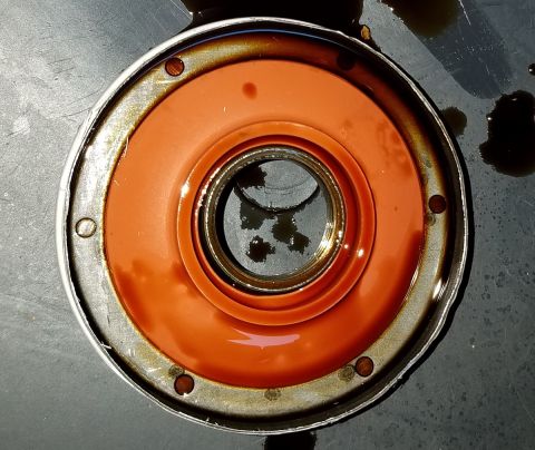 2000 Ford Crown Victoria - This oil filter shows signs of use with dark oil staining the orange seal and surrounding metal.