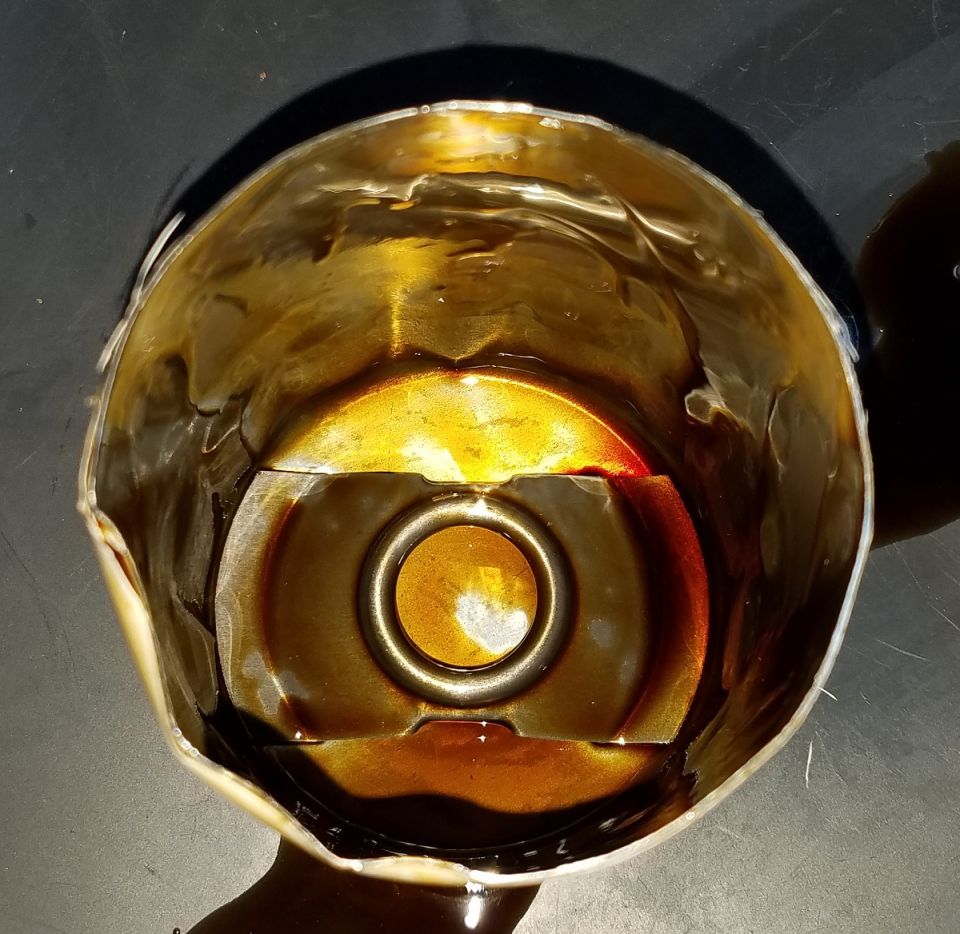 Used oil filter with dark oil residue inside