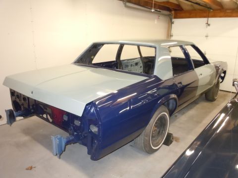 2001 Ford Crown Victoria - This sedan, possibly a Ford Crown Victoria project, is in a garage with its front end disassembled and body panels primed.