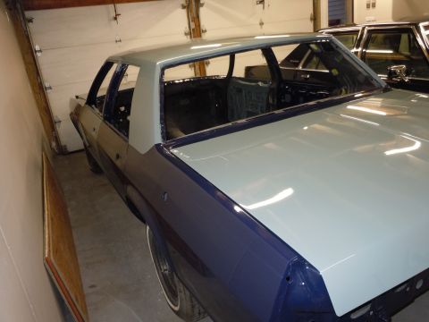 2001 Ford Crown Victoria - Car body undergoing restoration in a garage, with a second vehicle partially visible.