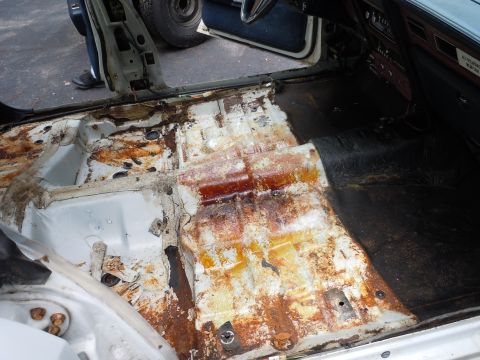 2001 Ford Crown Victoria - The interior floor of a vehicle shows extensive rust and discoloration, indicating significant damage.