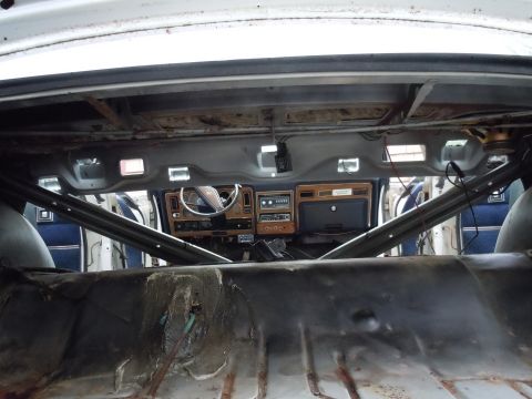 2001 Ford Crown Victoria - The interior of a car shows a roll cage and a dashboard with wood trim, indicating a modified vehicle.