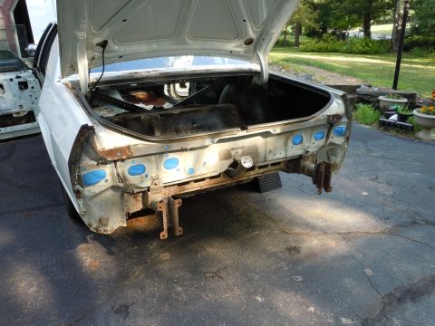 2001 Ford Crown Victoria - Rear view of a 2001 Ford Crown Victoria undergoing disassembly, with the trunk open and bumper removed.