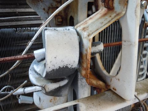 2001 Ford Crown Victoria - The corroded fan motor and mounting bracket are visible against the vehicle's radiator fins.