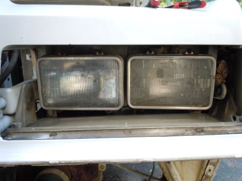 2001 Ford Crown Victoria - Close-up of two vehicle headlights, likely for replacement or repair.