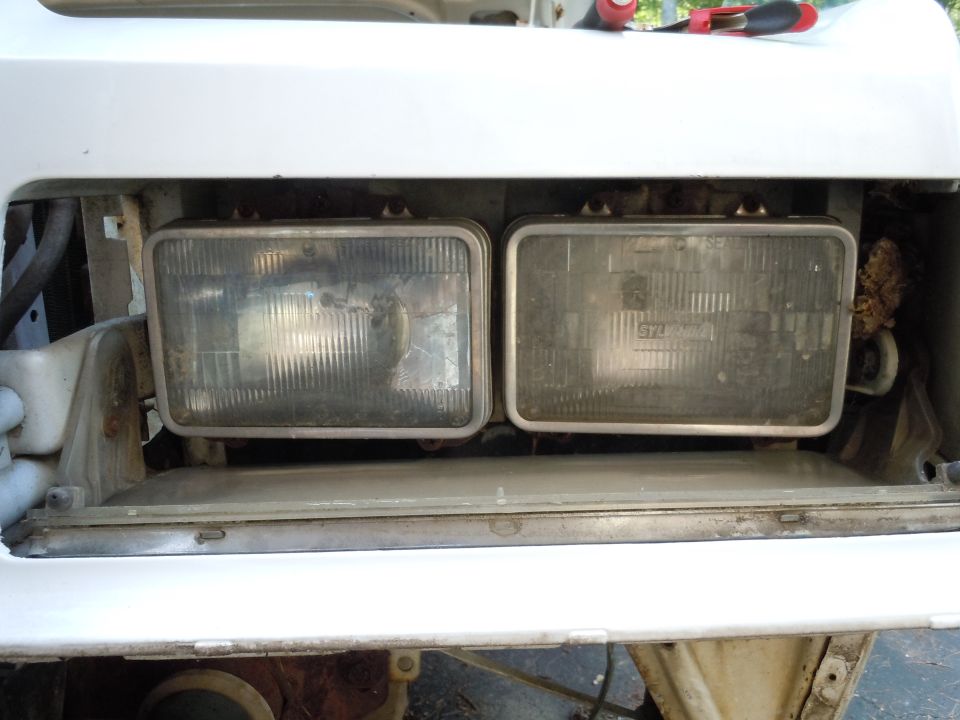Two rectangular headlights mounted in a white bumper assembly