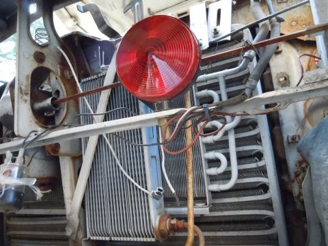 2001 Ford Crown Victoria - The front of a vehicle, focusing on the radiator and associated plumbing, with a prominent red light.