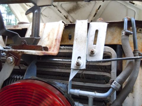 2001 Ford Crown Victoria - Close-up view of a vehicle's engine bay, showing the radiator and hood latch assembly.