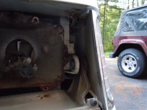 2001 Ford Crown Victoria - The interior of a vehicle's taillight housing shows significant rust and damage, with another vehicle visible in the background.