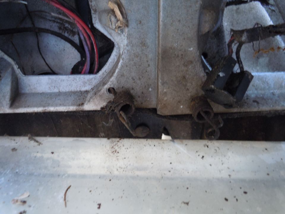 Close-up of automotive wiring and a metal linkage with springs