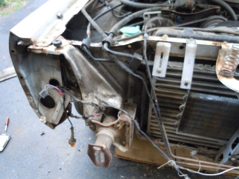 2001 Ford Crown Victoria - The front end of a white 2001 Ford Crown Victoria shows damage and exposed engine parts.