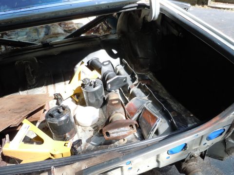 2001 Ford Crown Victoria - The interior of a car trunk is filled with various disassembled parts and tools.
