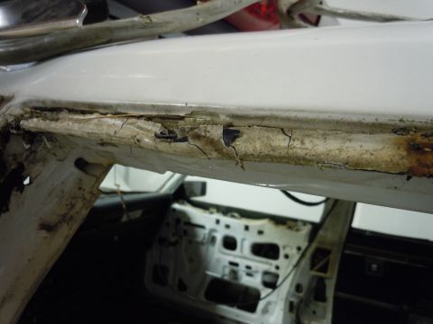 2001 Ford Crown Victoria - The interior of a car shows significant rust and damage to the A-pillar and door frame, with the door panel removed.