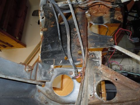 2001 Ford Crown Victoria - Close-up view of a heavily rusted vehicle chassis, revealing internal wiring and structural damage.
