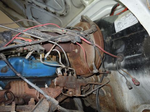 2001 Ford Crown Victoria - Close-up view of a vehicle's engine bay, showing a blue valve cover, brake booster, and a complex wiring harness.