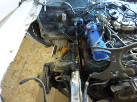 2001 Ford Crown Victoria - The engine bay and front suspension of a vehicle are shown, with many parts disassembled or exposed.