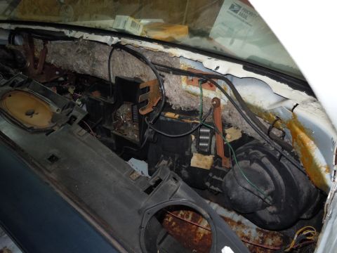 2001 Ford Crown Victoria - The interior of a vehicle shows a disassembled dashboard with exposed wiring and insulation, revealing the inner workings of the climate co…